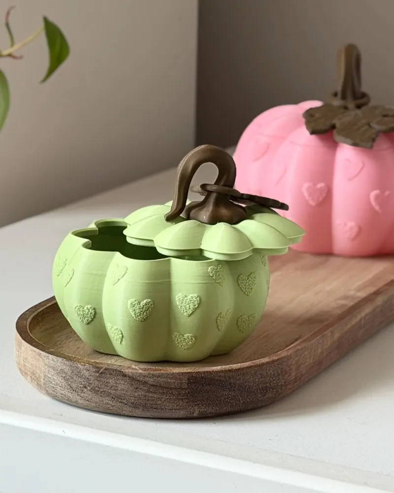 Green and pink pumpkin storage boxes, one with its lid off
