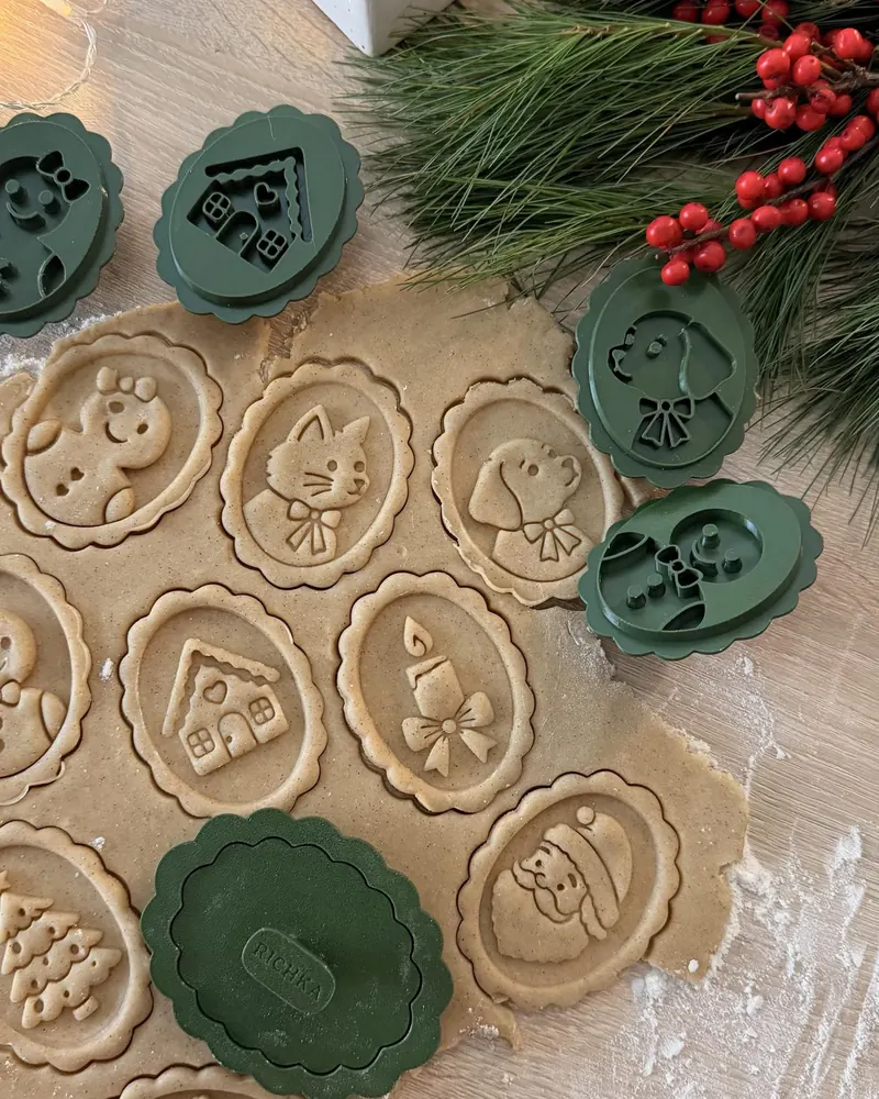 Gingerbread dough stamped with portrait cookies — cat, puppy, house, candle, Santa — with green RICHKA stamps and pine