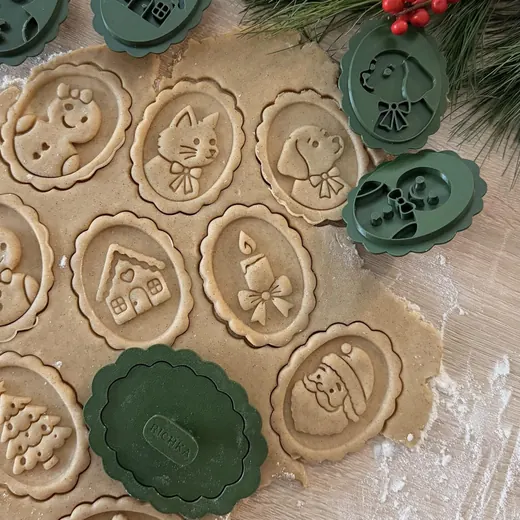 Stamped Christmas cookies on rolled dough with green stamps and pine