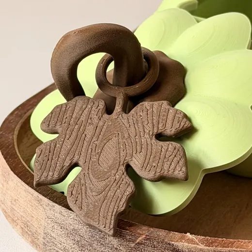 Close-up of the wood-textured leaf charm on a green pumpkin box